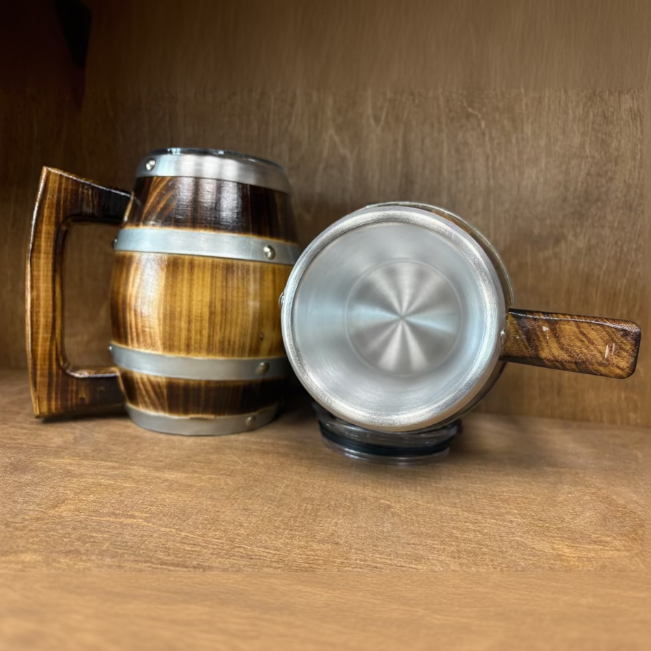 A wooden and metal mug shown from two angles: standing upright on the left with a dark stained wood barrel-like body, silver metal bands, and a handle, and lying on its side on the right showing a brushed silver interior and a wooden handle.